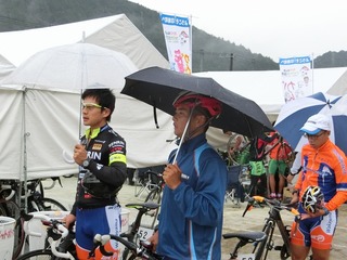 傘を差して検車を待つ(左から)窪木・岡本・山本